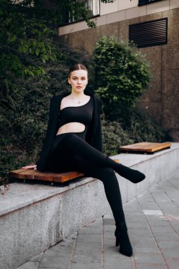 İnce, güzel sarışın manken yazın sokakta poz verir.