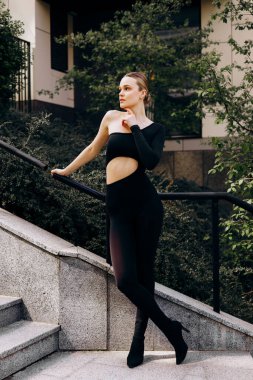 İnce, güzel sarışın manken yazın sokakta poz verir.