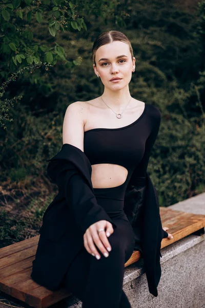 İnce, güzel sarışın manken yazın sokakta poz verir.