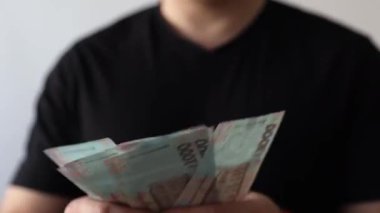Adam parayı sayıyor ve elinde tutuyor. Ukrayna bin hryvnia enflasyonu