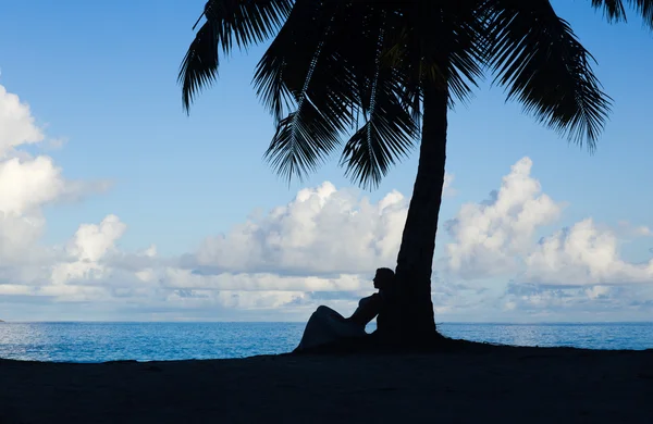 Playa tropical, palmera con mujer sentada, silueta — Foto de Stock