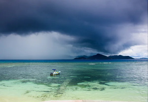 Tropical storm over an island, motor boat — Stock Photo, Image