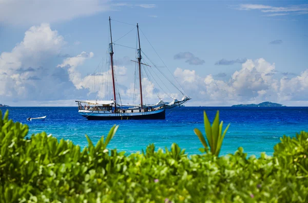 Old wooden sailing ship in tropical harbor, blue water — Stock Photo, Image