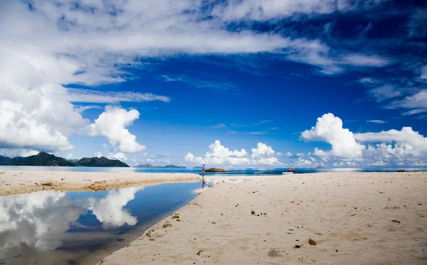 Seychelles playa isla, cielo azul, nubes, reflejando la superficie del agua, mujer —  Fotos de Stock