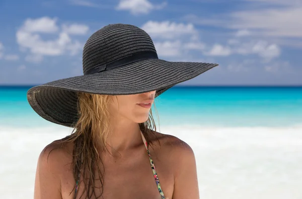 Mulher loira bonita com chapéu preto, e praia tropical — Fotografia de Stock