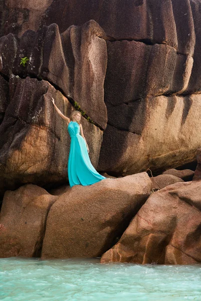 Hermosa mujer rubia, vestido largo azul turquesa, rocas, al aire libre — Foto de Stock