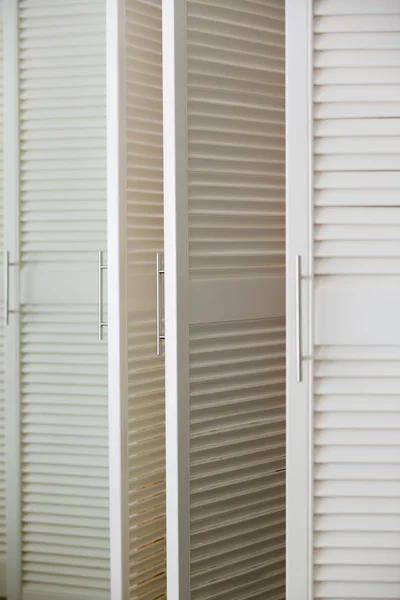 Белая люверсная дверь шкафа с ручкой — стоковое фото