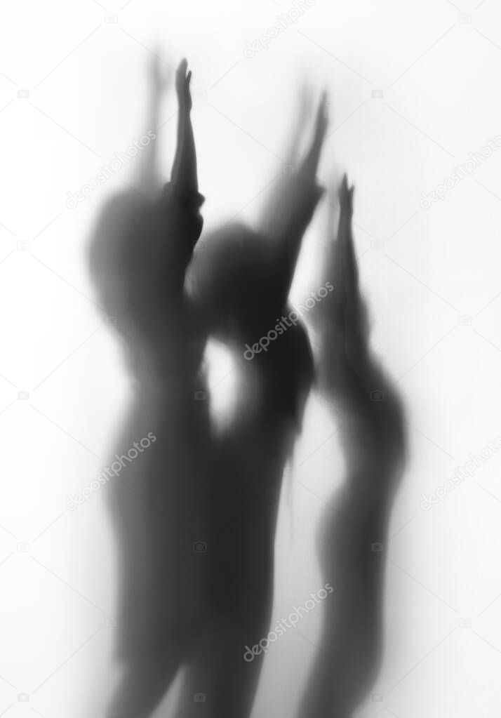 Diffuse body shape silhouette of three people in black and white.