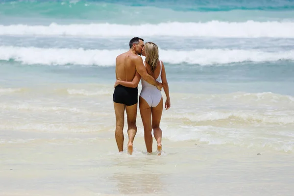 美しい恋人のカップルは新婚旅行を楽しみ 熱帯の島のビーチでお互いにキスをします — ストック写真