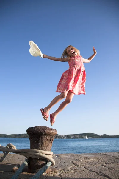 Feliz Niña Rubia Caucásica Salta Vestido Verano Rosa Zapatillas Con Imágenes de stock libres de derechos