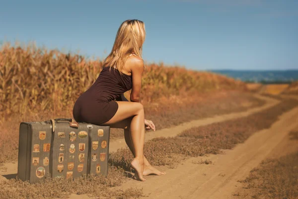 Mulher sentada na mala de bagagem — Fotografia de Stock