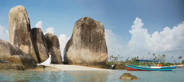 Enormes rocas en Indonesia, barco azul y mujer vestido blanco —  Fotos de Stock
