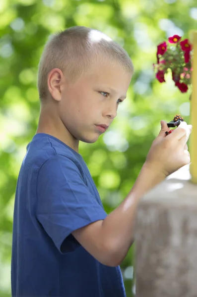 Blond pojke spelar i trädgården — Stockfoto