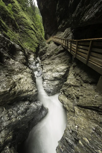 Hidden canyon with fast flowing water and an artificial pathway — Stock Photo, Image