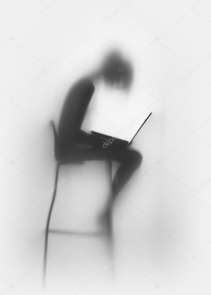 Slim woman with laptop computer, sitting on a chair, silhouette
