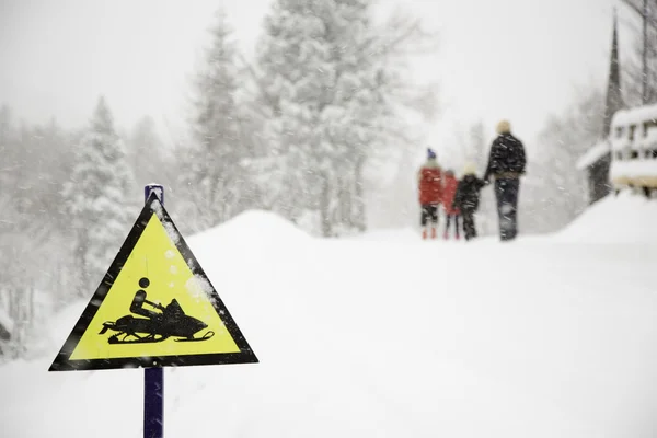 Mrożone skuter znak i fogy, śnieżny tło z chodzeniem rodziny — Zdjęcie stockowe