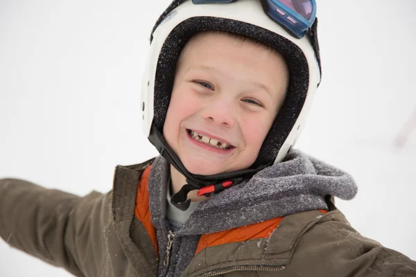 Gelukkig, vrolijke jongen lacht op helm, witte achtergrond — Stockfoto