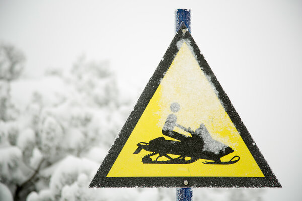 Snow mobile warning sign in winter time