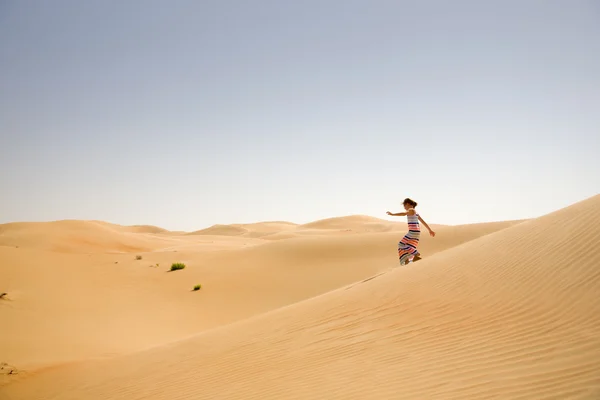 Chica joven juega entre dunas de arena en el desierto —  Fotos de Stock