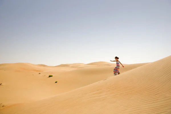 Giovane ragazza gioca tra dune di sabbia nel deserto — Foto Stock