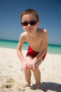 Genç çocuk güneş gözlüğü kumsal kameraya bak