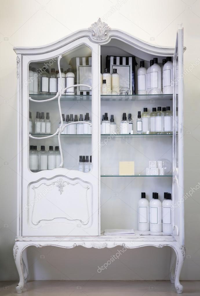 Old style, white baroq cabinet with bottles