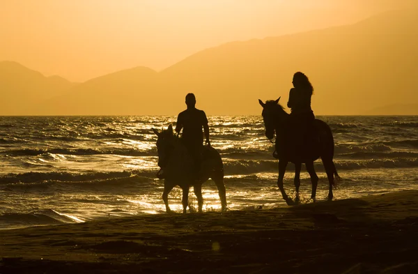 Para jeździec konia na zachód słońca plaża, nad samym morzem — Zdjęcie stockowe