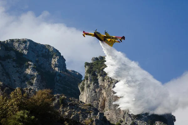 Yellow fire fighter aircraft drops all the water — Stock Photo, Image