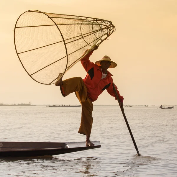 Burmese fisherman on bamboo boat catching fish in traditional way with handmade net. Inle lake, Myanmar (Burma) — Stock Photo, Image