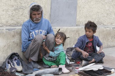 Dilenci aile Leh, yoldan geçen para için yalvarır. Hindistan