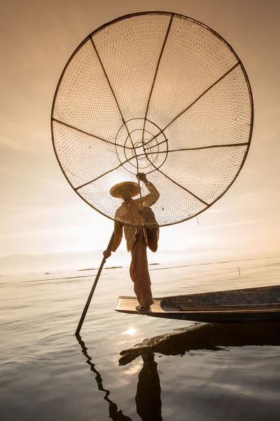 Burmesischer Fischer auf einem Bambusboot, das auf traditionelle Weise mit handgefertigten Netzen Fische fängt. inle lake, myanmar (burma) — Stockfoto