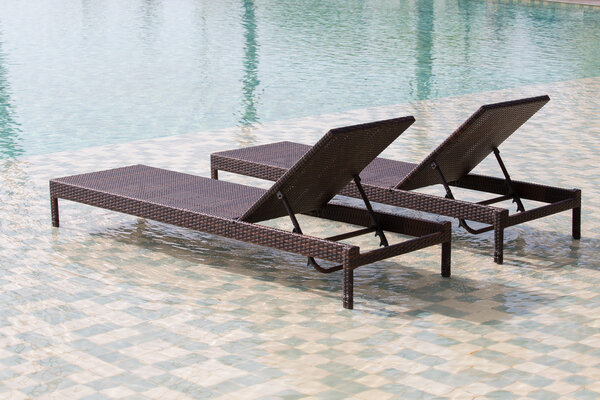 Swimming pool and two deck chairs, close up