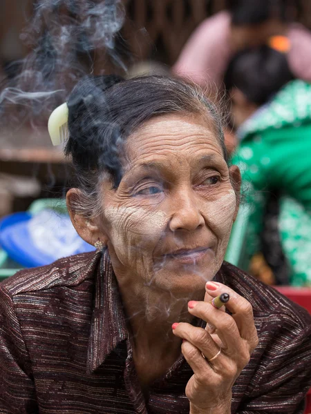 年长一些的女士坐在街上抽着烟。缅甸仰光 — 图库照片