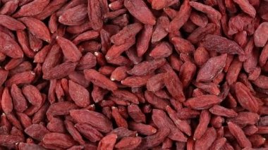 Kurutulmuş Goji meyveleri. Kameranın ön kısmında plaka parlak çilek Goji ile döner. Yakın çekim