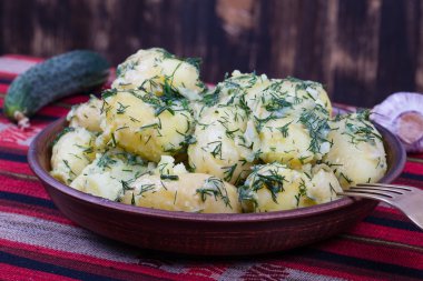 Haşlanmış patates dereotu ve sarımsak tereyağı bir plaka üzerinde