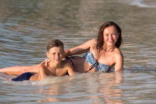 Μητέρα και γιος σε μια παραλία στο θαλασσινό νερό. — Φωτογραφία Αρχείου