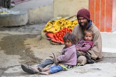 Leh, Ladakh'ta sokakta dilenen çocuklu dilenci adam. Hindistan