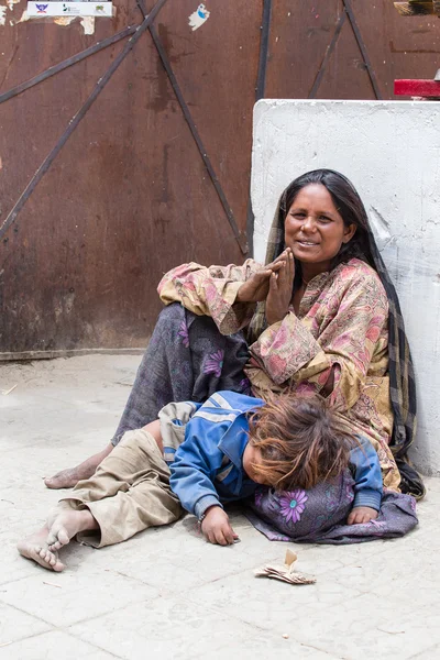 Donna mendicante con un bambino che implora nel tempio buddista di Leh, Ladakh. India — Foto Stock