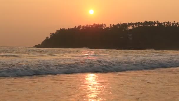 Морские волны и песок на пляже во время заката — стоковое видео
