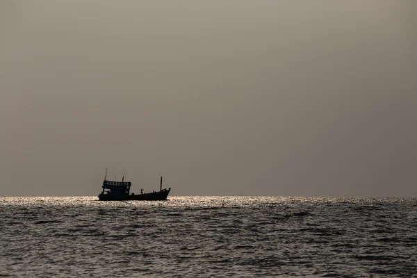 Silhouette boat and sunset over the sea water — Stock Photo, Image