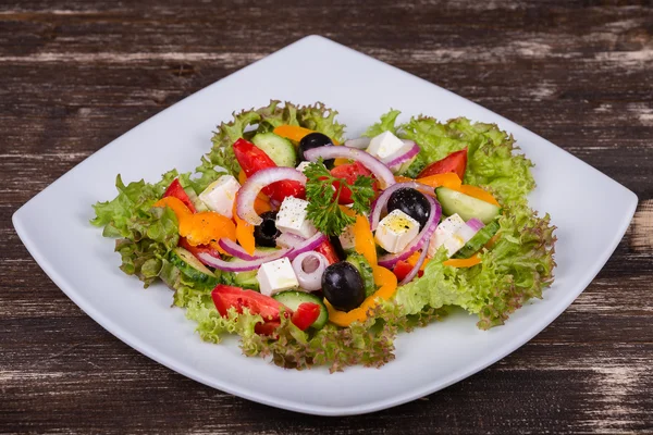 Frischer griechischer Gemüsesalat auf dem Tisch — Stockfoto
