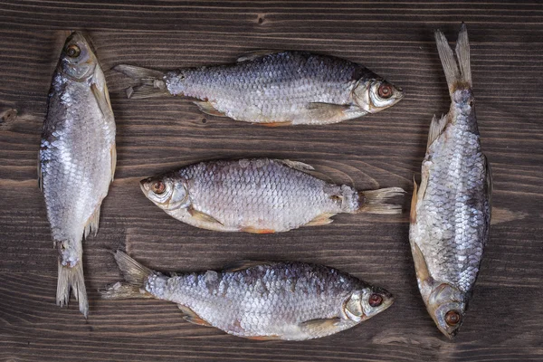 Pesce secco su uno sfondo di legno — Foto Stock