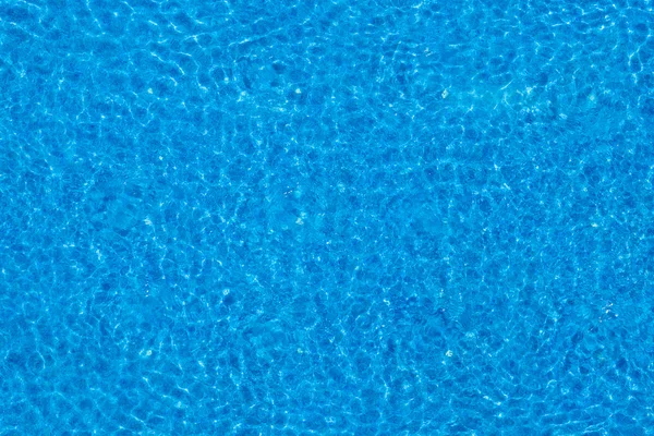 Ondulations d'eau sur fond de piscine carrelée bleue . — Photo