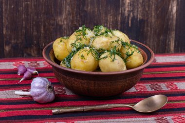 Haşlanmış patates dereotu ve sarımsak tereyağı bir plaka üzerinde
