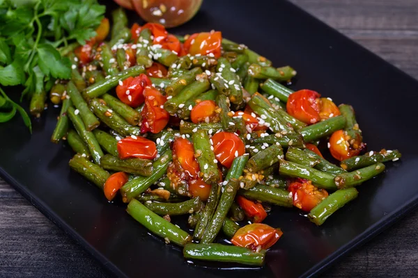 Haricots verts sains, tomates cerises rouges aux graines de sésame — Photo