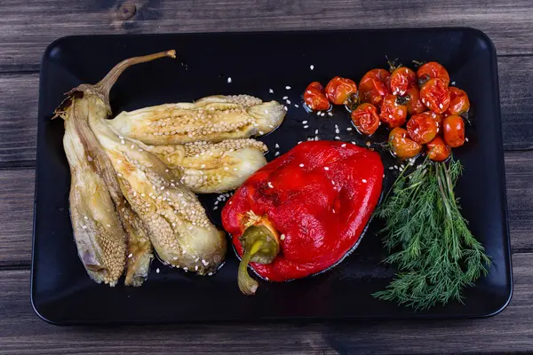 Légumes rôtis en assiette noire — Photo