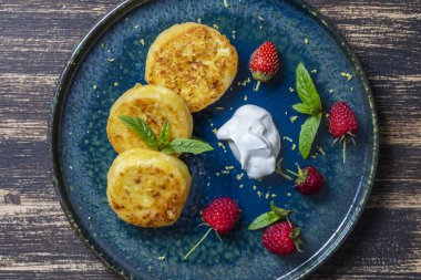 Naneli peynirli kek, ahududu, bal ve ekşi krema. Lezzetli tatlı, Ukrayna yemeği. Kapat, üst görünüm