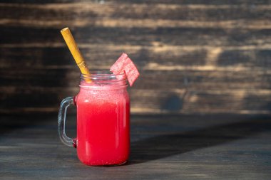 Ahşap arka plandaki cam kavanozda taze karpuz smoothie var, kapat. Sağlıklı gıda konsepti