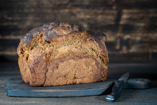 Trä Skärbräda Med Limpa Svart Bröd Och Kniv Träbord Närbild — Stockfoto