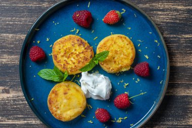 Naneli peynirli kek, ahududu, bal ve ekşi krema. Lezzetli tatlı, Ukrayna yemeği. Kapat, üst görünüm